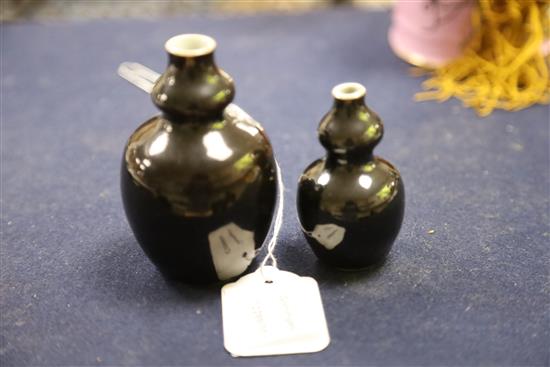 Two Chinese miniature black glazed double gourd vases, 18th century, H. 9.5cm and 7.4cm, tiny rim chip, wood stands